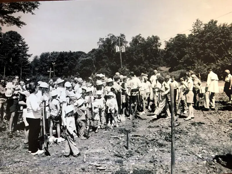 Historic groundbreaking ceremony with congregation members and children holding shovels