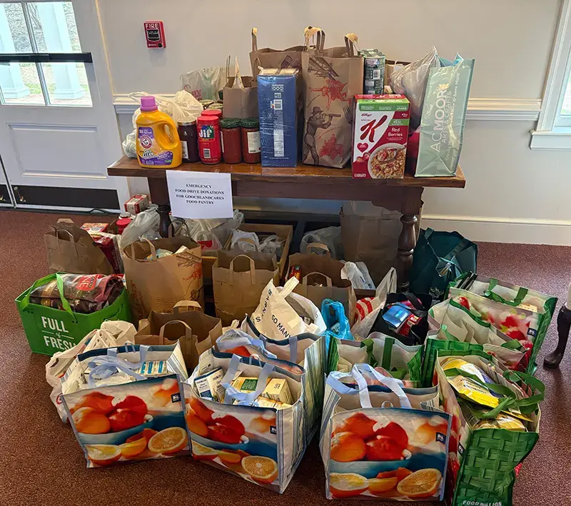Bags of donated groceries and household items arranged for community outreach.